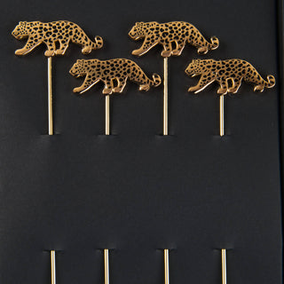 Leopard Cocktail Picks - Holt x Palm -  Leopard swizzlers to gussy up your drinks. An alluring set 4 of cocktail picks adorned with elegantly leaping leopards. Gold picks with black enamel finish, packaged in our custom printed box. Approximate dimensions: 4” long pick with 0.5 x 1.25” leopard. Hand Wash