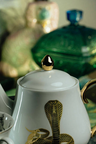 The Most Adorable Cobra Teapot w/ Gift Box - Holt x Palm -  Sippin' tea never looked so cool! Check out our ceramic 24K gold laced Cobra tea-pot...pair this beauty with one of our Poison or Queen tea cups and you have the most unique and unexpected gift for someone amazing...or yourself :-). You deserve it! Plated 24K gold material from Germany. 6" H (including lid) 6" L (handle to spout) 5" W.