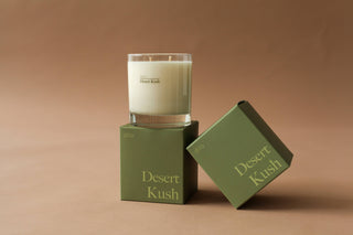 Desert Kush Candle - Holt x Palm -  Light up the 'DESERT KUSH CANDLE' for a scorching hot time. This clean burning, good smelling candle adds a hip and cool vibe to your space. Feel the heat (but in a good way)! Top Notes: Tangelo - Italian Bergamot Heart: Cannabis Flower - Cypress - Moss Base: Vetiver - Patchouli - Leather 8.5 ounces Burns 45 Hours All candles are Phthalate-free, using cotton wicks with no lead cores for safer, cleaner burning.