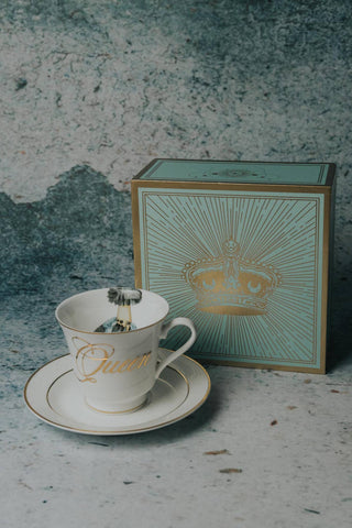 The Queens Tea Cup w/ Gift Box - Holt x Palm -  Regale yourself in the luxury of our newest collection of fine Bone China from Spitfire Girl. Do you want to treat her like the Queen she is? Or treat yourself because you are a Queen that only deserves the best. All Teacups come with a cup and saucer and are packaged in an elegant blue gift box with 24K gold accents. Plated 24k gold material from Germany Dishwasher safe Cup measures 6" Cup 3.5" w 3.10 h