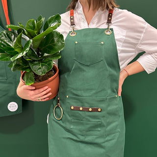 Gardening Apron - Green - Holt x Palm -  Our recycled canvas gardening apron is adjustable, functional, and chic! With thoughtful brass details that help budding greenthumbs hold their gardening essentials while effortlessly moving from space to space. This apron suits all body types and is packaged to be wrapped easily. It makes a great gift for any occasion! Plus, it's made from recycled materials - that's better for the people AND the planet!