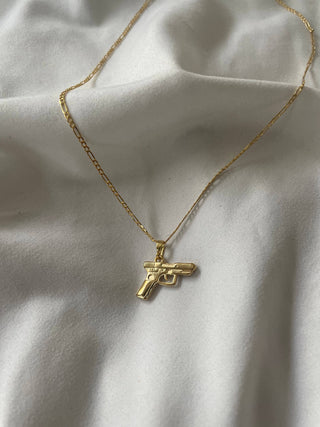 Bang Bang 24k Gold Gun Chain Necklace - Holt x Palm -  Get ready to turn heads with the Bang Bang 24k Gold Gun Chain Necklace. This super cool accessory is gold filled, giving it a stunning shine that will keep you looking fly. Channel your inner boss and keep it G with this one-of-a-kind piece. 17.5” Figaro chain