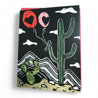 Cacti Balloon Card - Holt x Palm -  Even things that are a little prickly can find ways to love. Reproduced from an original linocut block print by ilikesara / Sara Schalliol-Hodge. -measures 4.5" x 5.5" when folded -printed on 100 lb white cover paper -includes red envelope -blank interior -shipped in a clear cellophane sleeve inside a rigid cardboard mailer