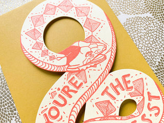 You're The Best Snake Card - Holt x Palm -  This snake card is truly the coolest way to let someone know they're simply the best. Perfect for any occasion, it's a fun and quirky way to show your appreciation. Who knew a snake could be so heartwarming? (No, really. It's super cute!) • flat shaped card is letterpress printed in bright coral ink on 100# manilla yellow paper • measures approximately 4”x8.75” • die cut & cut to hold a gift card, money, tickets, or a love note • accompanied by a #10 envelope