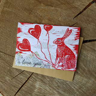 Greeting card | i love you bunny - Holt x Palm -  i love you bunny Show some bunny you love them with this card. Reproduced from an original mixed-media block print by ilikesara / Sara Schalliol-Hodge, which features collaged map mountains, text clouds, and linocut printing. Card measures 4.25" x 5.5" when folded. Printed on 100 lb cream cover paper. Kraft envelope included. Blank interior. Packaged in a clear cellophane sleeve. Designed and printed in Denver, Colorado.