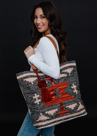 Faded Black, Tan & Red Aztec Tote - Holt x Palm -  Go bold and bohemian with our Faded Black, Tan & Red Aztec Tote! This extra large tote is perfect for carrying all your essentials in style. Embrace your free-spirited side with the timeless Aztec design. It's a tote, it's a statement piece - it's everything you need. Aztec-chic never looked so good! Description: Faded black, tan, red & rust Aztec tote w/ Red pom tassel detail 17" x 6.5" x 14.5" 100% Cotton Min.