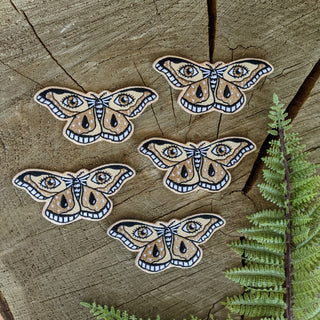 Patch | moth - Holt x Palm -  The all-seeing moth of protection. Based on an illustration by ilikesara / Sara Schalliol-Hodge. -3.4" x 1.6" -iron-on backing *ilikesara single patches are sold loose / packaging free in an effort to reduce unnecessary waste.* instructions for ironing: Place the patch on your garment and cover the patch with a piece of fabric. Iron on high heat for 30-45 seconds. Turn the garment inside-out and iron on reverse side of the patch for 30-45 seconds.